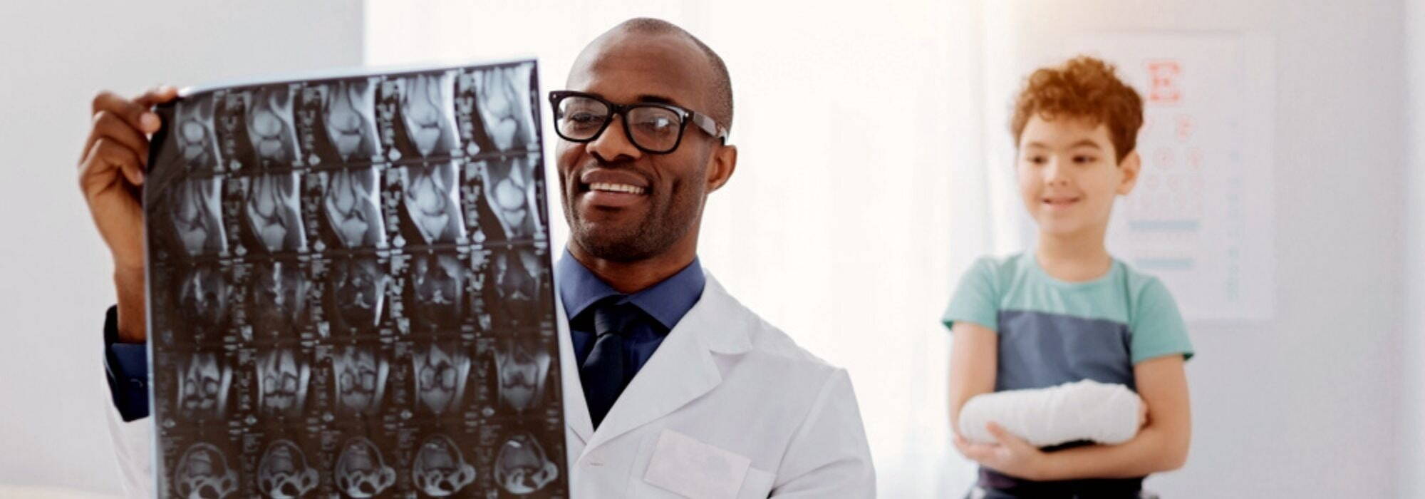 Imaging professional looking at arm xray with patient