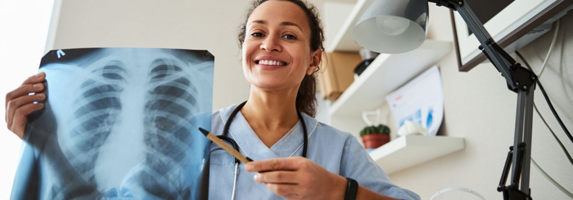 Imaging professional wearing scrubs holding an xray