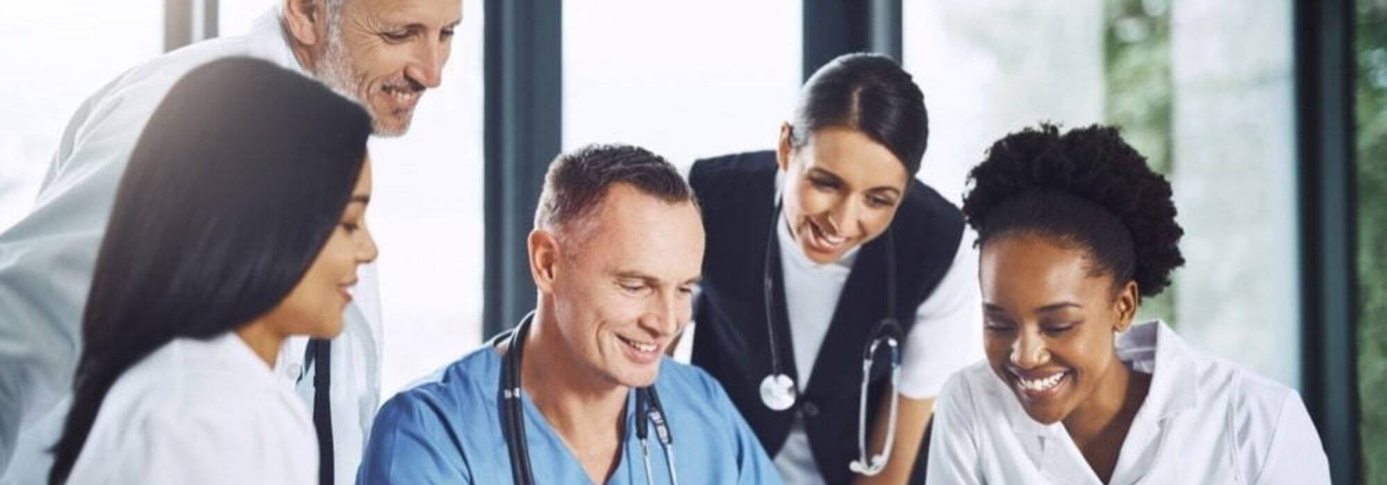 Group of healthcare professionals looking at a laptop